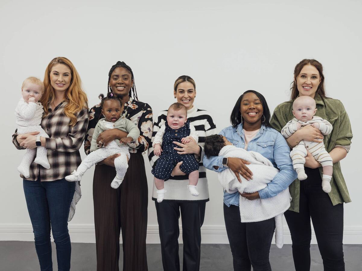 A group of five women smiling and holding babies.