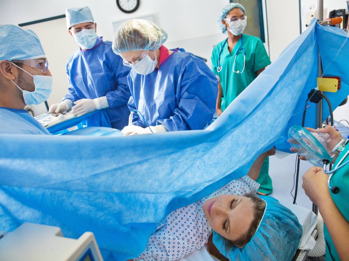 Surgeons and medical staff performing a C-section on a woman.